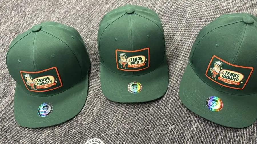 Texas Quality Plumbing branded caps with the company's mascot patch
