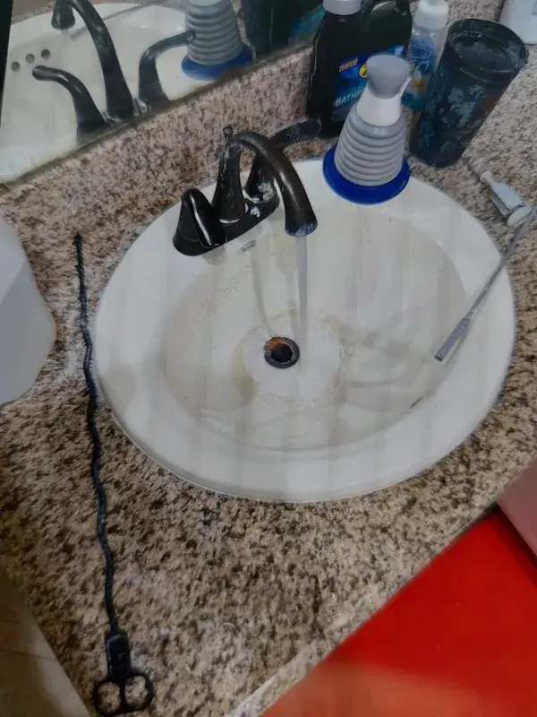A bathroom sink draining freely after a clog was cleared in Katy