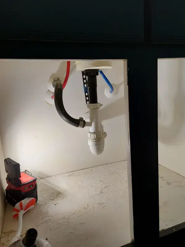 New faucet supply lines and drain assembly installed under a Cypress bathroom sink