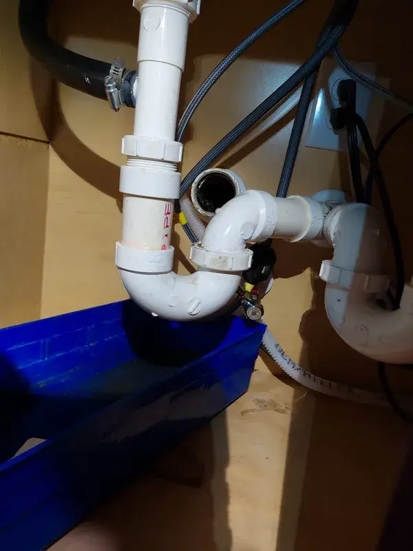 Kitchen sink drain lines opened up under the cabinet for a clog in Katy