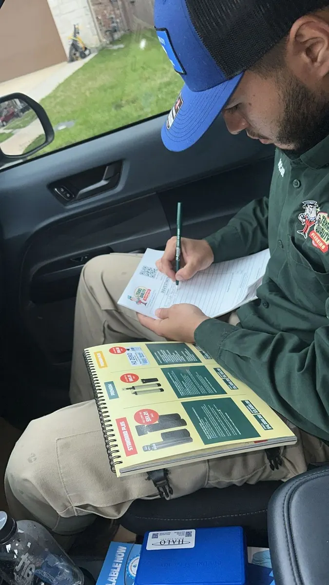 A Texas Quality plumber writing up an upfront estimate for a Houston customer