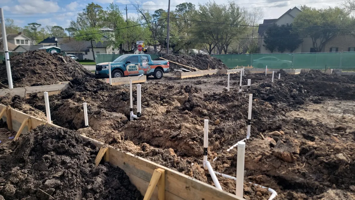 A Texas Quality Plumbing truck on a new-construction slab rough-in job site in Greater Houston