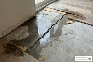 cracked concrete slab foundation with visible slab leak water damage