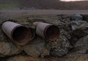 neglected home plumbing system with visible pipe corrosion and water stains